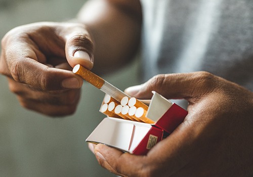 Man pulling cigarette from pack