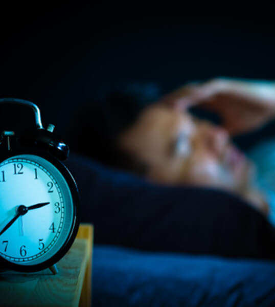 a restless person with an alarm clock in the foreground 