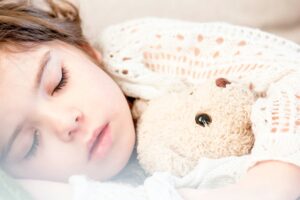 Sleeping child hugging a teddy bear