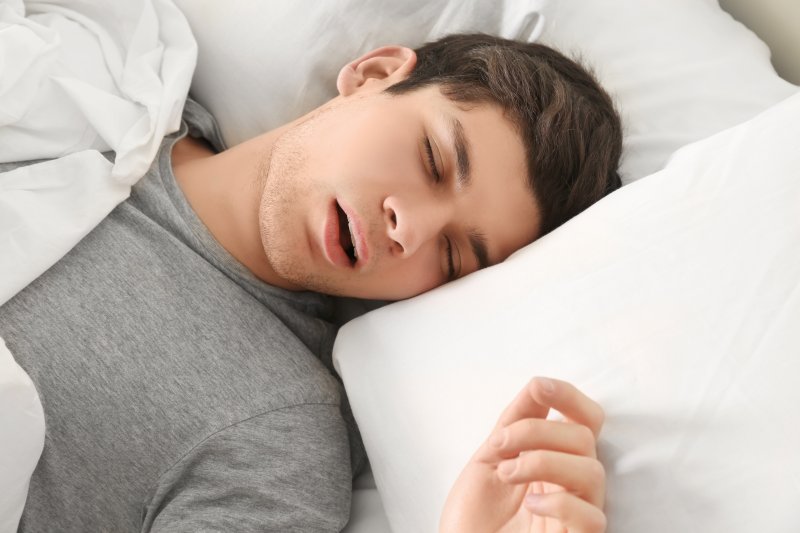 man asleep in bed and snoring